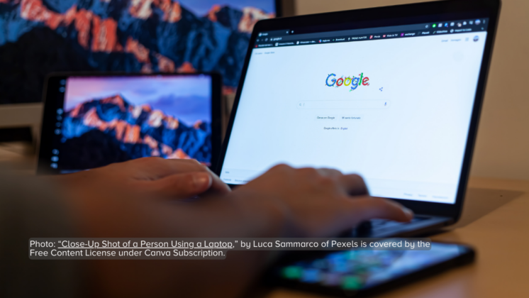 Close-up shot of a person's hands typing on a laptop keyboard with the Google Homepage on the screen.